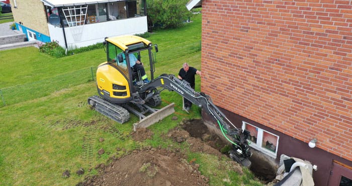 grävskopa utför en dränering - gårdsmark